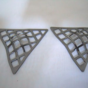 May include: A pair of silver triangle-shaped earrings with a geometric, grid-like design.