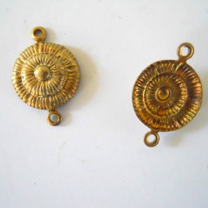 May include: Two gold-toned metal connector pieces with a circular design. Each piece has two loops for attaching to other jewellery or crafts.