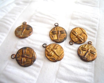 May include: Six gold-toned metal charms featuring a dragonfly design. Each charm has a loop for attaching to a necklace, bracelet, or other jewelry.