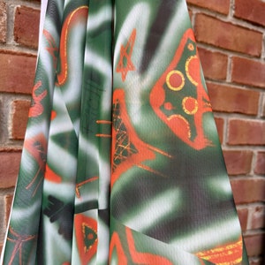 May include: Green and orange fabric with a white background and a geometric pattern. The fabric has a sheer, mesh-like texture.