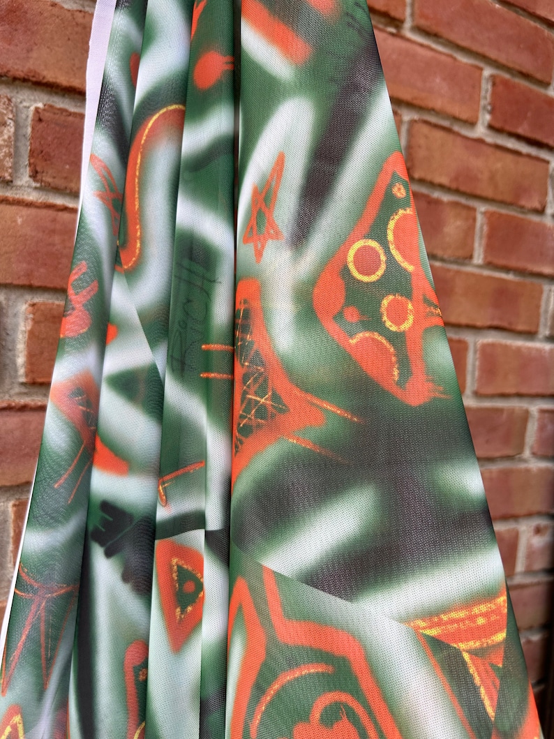 May include: Green and orange fabric with a white background and a geometric pattern. The fabric has a sheer, mesh-like texture.