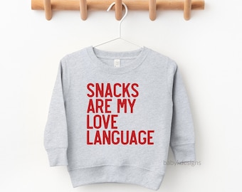 May include: A grey sweatshirt with the text "SNACKS ARE MY LOVE LANGUAGE" printed in red.