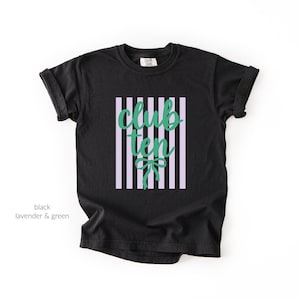 May include: A black short-sleeved t-shirt featuring a central graphic of vertical lavender stripes. Overlaid on the stripes is the text "club ten" in a green cursive script, with a small green bow icon positioned directly below the lettering.