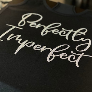 May include: Black tank top with the text "Perfectly Imperfect" in silver glitter lettering.