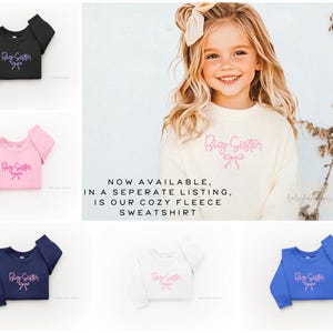 May include: A cream-colored fleece sweatshirt with the text "Big Sister" in pink script and a bow graphic. The image also shows the sweatshirt in black, pink, navy, white, and blue. The text "NOW AVAILABLE, IN A SEPERATE LISTING, IS OUR COZY FLEECE SWEATSHIRT" is also visible.