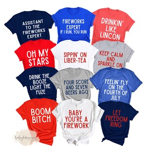 Op de afbeelding: Een verzameling van 10 T-shirts met verschillende patriottische en humoristische slogans die in rood en wit zijn gedrukt op verschillende gekleurde shirts. De slogans zijn: "Assistant to the Fireworks Expert", "Fireworks Expert If I Run, You Run", "Sippin' on Liber-Tea", "Drink the Booze Light the Fuze", "Boom Bitch", "Baby You're a Firework", "Keep Calm and Sparkle On", "Feelin' Fly on the Fourth of July", "Let Freedom Ring", en "Drinkin' Like Lincon".