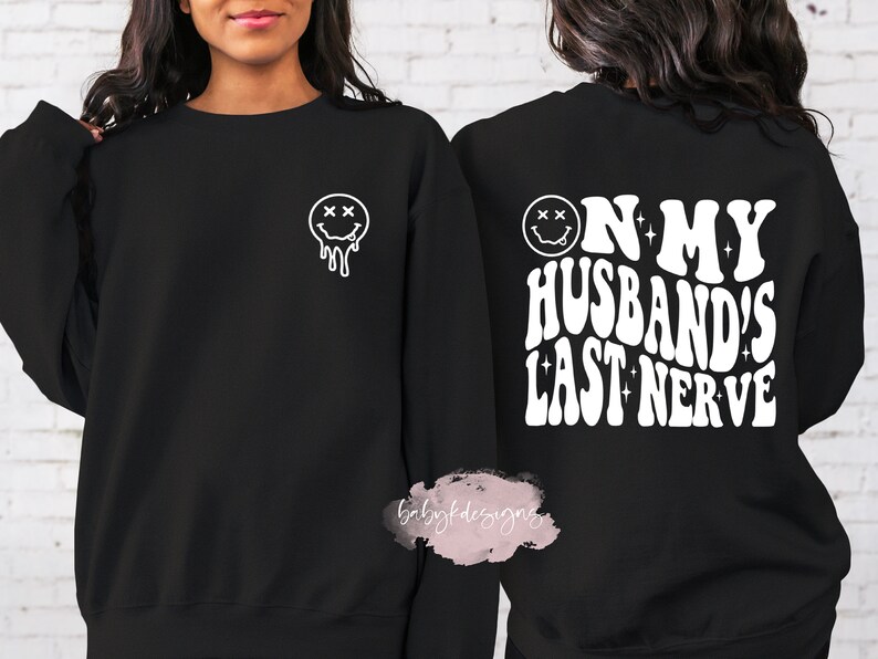 May include: Two black sweatshirts with white text and a smiley face graphic. One sweatshirt says "On My Husband's Last Nerve" and the other has a dripping smiley face.