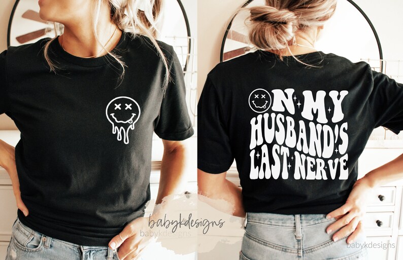 May include: Black t-shirt with a white dripping smiley face on the front and the text "On my husband's last nerve" in a retro font on the back.