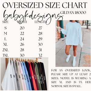 May include: Size chart for Gildan 18000 oversized sweatshirts, showing width and length measurements in inches for sizes S through 3XL. The chart also includes a photo of a model wearing a white sweatshirt, with text explaining that the model is wearing a size XL and is 5'5" tall. The text also states that for an oversized look, please size up at least two sizes.