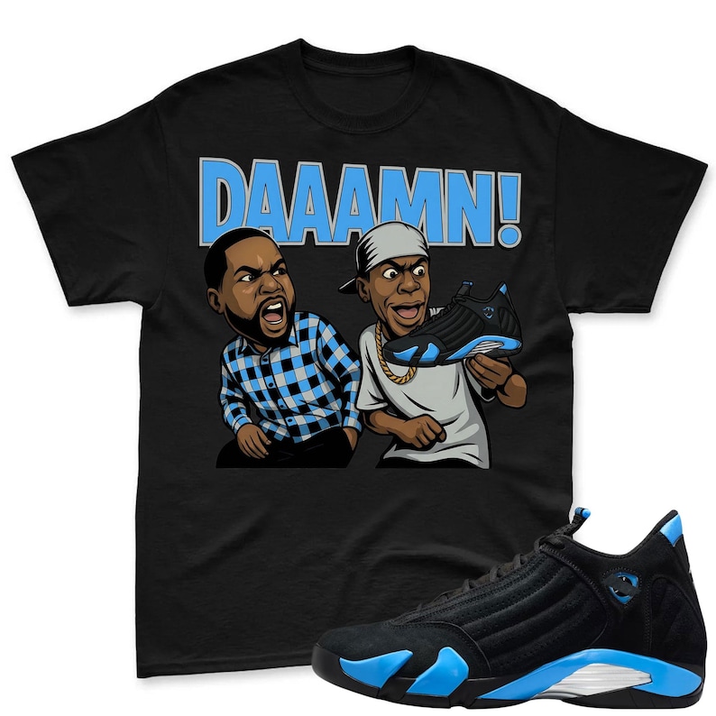 May include: Black t-shirt with the word "DAAAMN!" in light blue, featuring cartoon illustrations of two men. A pair of black and light blue sneakers are in the foreground, with a matching sneaker held by one of the cartoon characters.