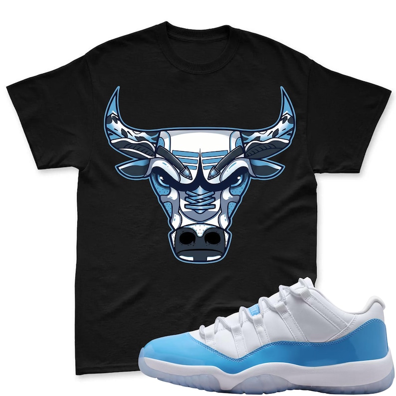 May include: Black t-shirt with a blue and white bull head design. The image also shows a pair of white and light blue trainers with a translucent sole. The items are likely part of a sports-themed collection, with the trainers and t-shirt complementing each other.