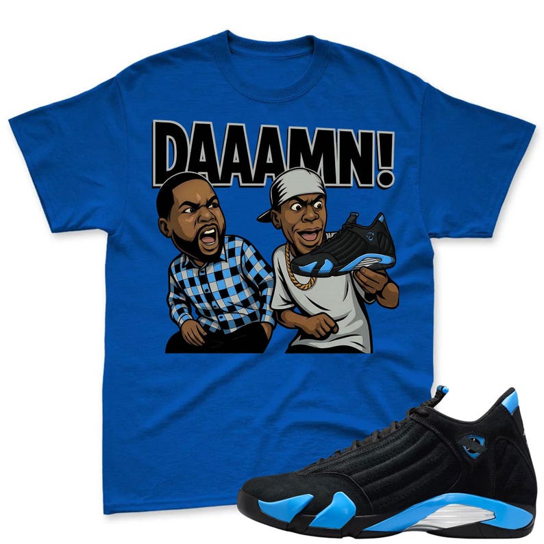 May include: Royal blue t-shirt with the word "DAAAMN!" in white block letters. The shirt features a cartoon graphic of two men, one holding a black and blue sneaker. A black and blue sneaker is in the foreground.