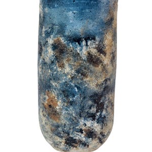 Könnte beinhalten: Eine zylindrische Keramikvase mit strukturierter Oberfläche. Die Vase weist eine Mischung aus blauen, braunen und weißen Farbtönen auf, die einen Marmoreffekt erzeugt. Der obere Rand ist leicht uneben. Die Vase ist etwa 20 cm hoch.