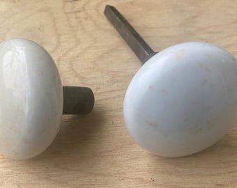 Antique vintage pair of white ceramic or porcelain door knobs with black cast iron spindle/shanks