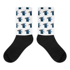 May include: A pair of black and white socks with a repeating pattern of a blue cartoon mouse. The mouse is smiling and has large ears.