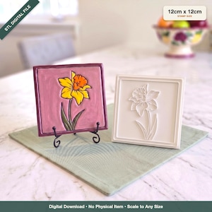 Può includere: Due piastrelle quadrate di 12cm x 12cm. Una piastrella è color malva con un disegno in rilievo di un narciso giallo e arancione, su un supporto in metallo nero. La seconda è bianca con un contorno di narciso in rilievo. Testo: STL DIGITAL FILE.