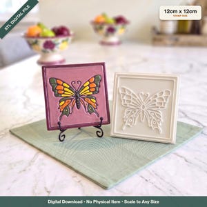 Könnte beinhalten: Zwei quadratische Fliesen mit den Maßen 12cm x 12cm. Eine Fliese ist malvenfarben mit einem erhabenen, bunten Schmetterling mit orangefarbenen, gelben und grünen Flügeln. Die zweite Fliese ist weiß mit einem erhabenen Schmetterlingsumriss. STL-Datei.