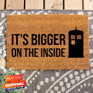 May include: A brown coir doormat with the text "IT'S BIGGER ON THE INSIDE" and a black silhouette of a TARDIS.
