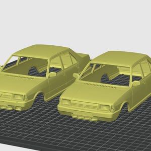 May include: Two yellow 3D-printed model cars. One is a coupe, the other a sedan. Both have detailed body lines, windows, and a chassis. They are displayed on a black grid surface.
