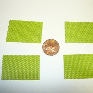 May include: Four lime green square mesh pads, each about the size of a US penny.