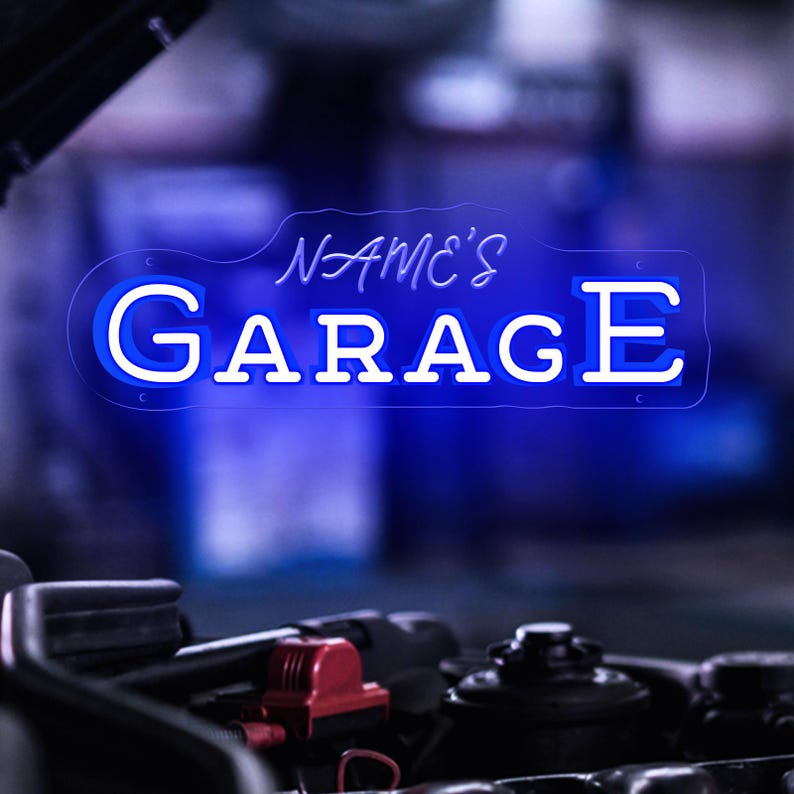 K&ouml;nnte beinhalten: Blaues Neon-Schild mit dem Text "NAME'S GARAGE" in wei&szlig;er Schrift. Das Schild leuchtet vor einem verschwommenen Hintergrund, mit dem Motor eines Autos im Vordergrund.