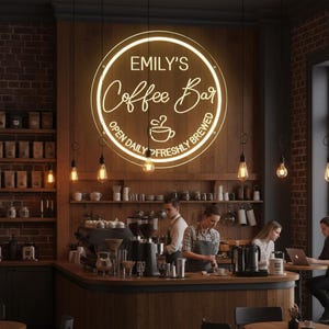 May include: A coffee shop interior with a large, circular neon sign that reads "Emily's Coffee Bar." The sign is surrounded by a wooden wall. Baristas are working behind the counter, and customers are seated at tables. The sign also says "Open Daily Freshly Brewed."