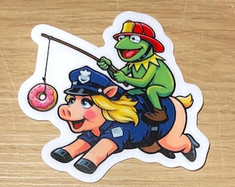 Donut Patrol Chaos – Firefighter Kermit & Police Miss Piggy Sticker