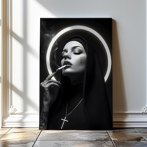 Könnte beinhalten: Schwarz-Weiß-Kunstdruck einer Nonne, die eine Zigarette raucht. Die Nonne trägt eine schwarze Kutte und eine Kreuzkette. Ein weißer Heiligenschein umgibt ihren Kopf. Der Druck wird in einem Raum mit Fenster und Fliesenboden ausgestellt.