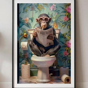 May include: A framed wall art print featuring a chimpanzee sitting on a white toilet, wearing pink glasses, and holding a newspaper titled The Daily Flush. The background shows a vibrant floral wallpaper with green leaves and pink flowers.