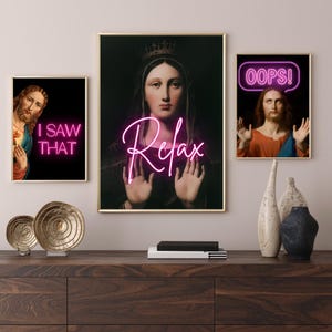 Könnte beinhalten: Drei gerahmte Drucke mit religiösen Figuren und pinkfarbenem Neontext. Der mittlere Druck zeigt eine Frau mit einer Krone und dem Text "Relax". Der linke Druck zeigt einen Mann mit Bart und dem Text "I saw that". Der rechte Druck zeigt einen Mann mit Bart und dem Text "Oops!"