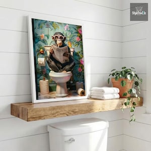 May include: A framed wall art print featuring a chimpanzee wearing pink sunglasses, sitting on a white toilet, and reading a newspaper titled The Daily Flush. The background shows a vibrant tropical floral pattern with green leaves and pink flowers.