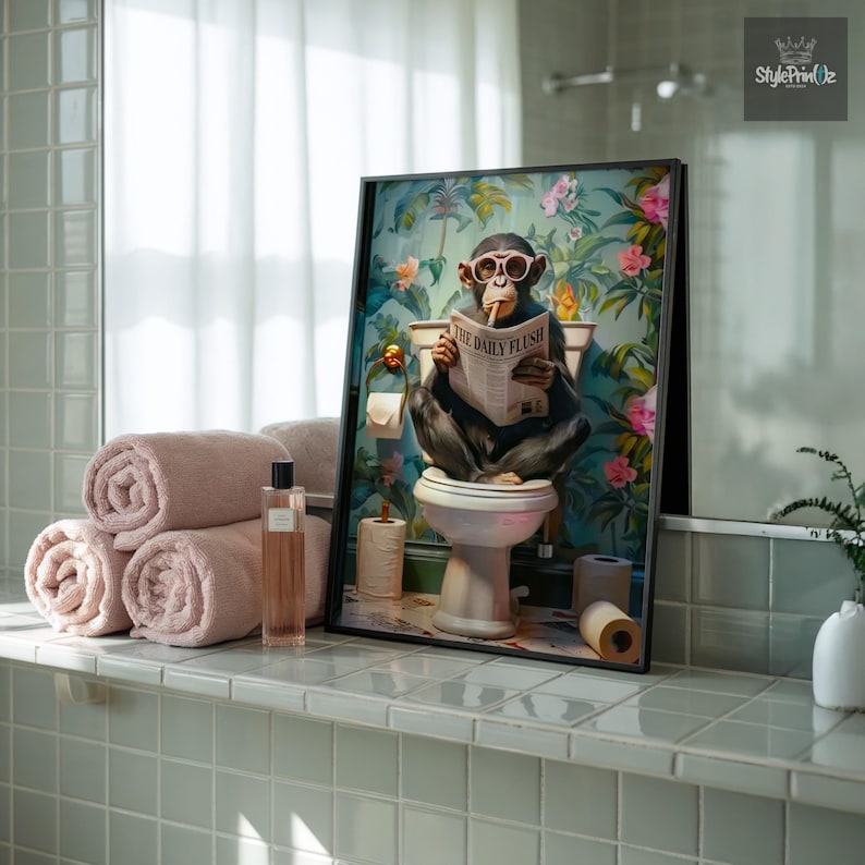 May include: A framed wall art print featuring a chimpanzee wearing round glasses, sitting on a white toilet, and reading a newspaper titled The Daily Flush. The background displays a vibrant tropical floral pattern with green leaves and pink flowers.