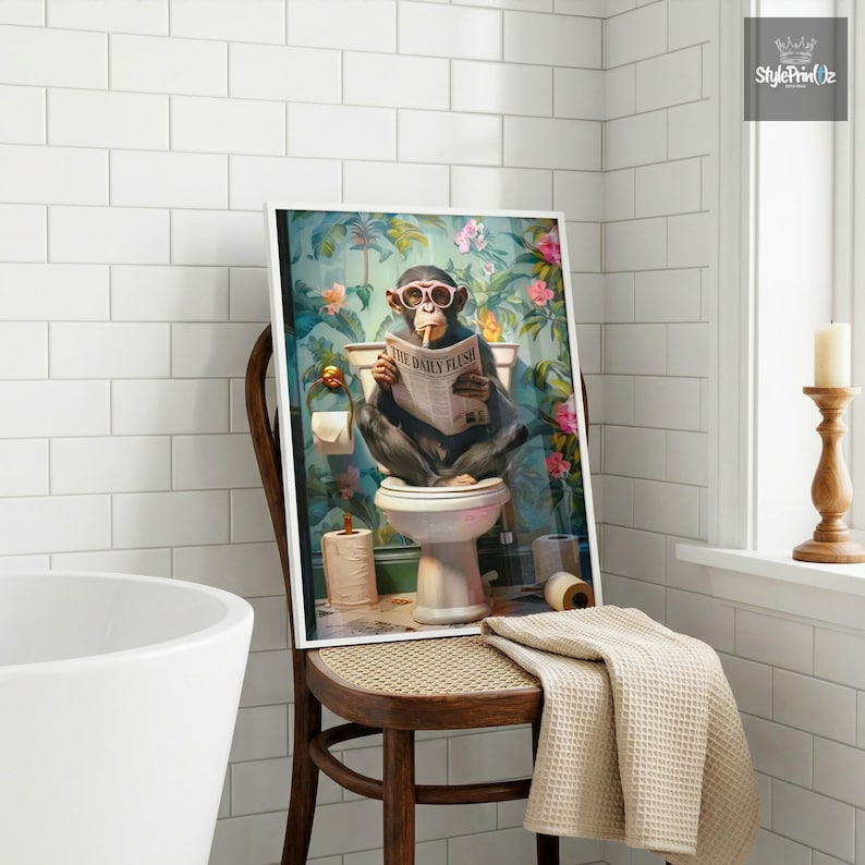 May include: A framed wall art print depicting a chimpanzee wearing pink-rimmed glasses, sitting on a white toilet, and reading a newspaper titled The Daily Flush. The background features a vibrant floral pattern with green leaves and pink flowers.