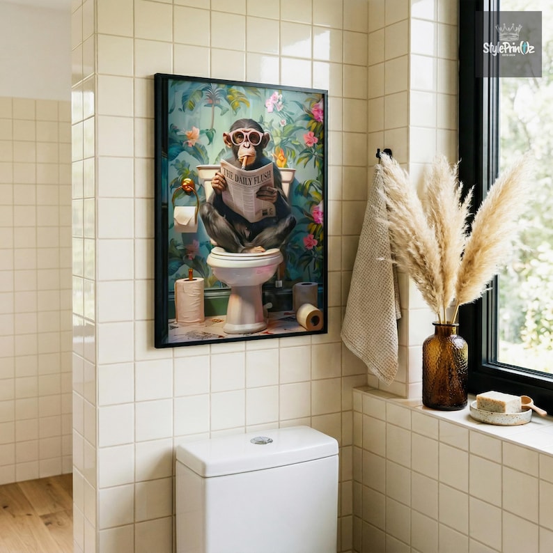 May include: A framed wall art print featuring a chimpanzee wearing pink sunglasses while sitting on a toilet and reading a newspaper titled The Daily Flush, set against a vibrant background of tropical green leaves and pink flowers.
