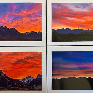 May include: Four photographs of a mountain range with a colorful sunset sky. The sky is a mix of pink, orange, and yellow. The mountains are silhouetted against the sky.