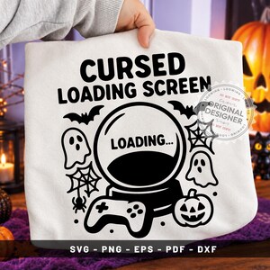 May include: A white t-shirt featuring a black graphic with the text CURSED LOADING SCREEN and LOADING inside a crystal ball. The design includes ghosts, bats, spiderwebs, a spider, a jack-o'-lantern, and a game controller, with SVG PNG EPS PDF DXF text.