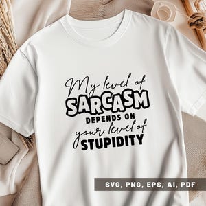 Pode incluir: Camiseta branca com o texto preto: "My level of Sarcasm depends on your level of Stupidity". A camiseta também inclui as opções de tipo de arquivo: SVG, PNG, EPS, AI e PDF.