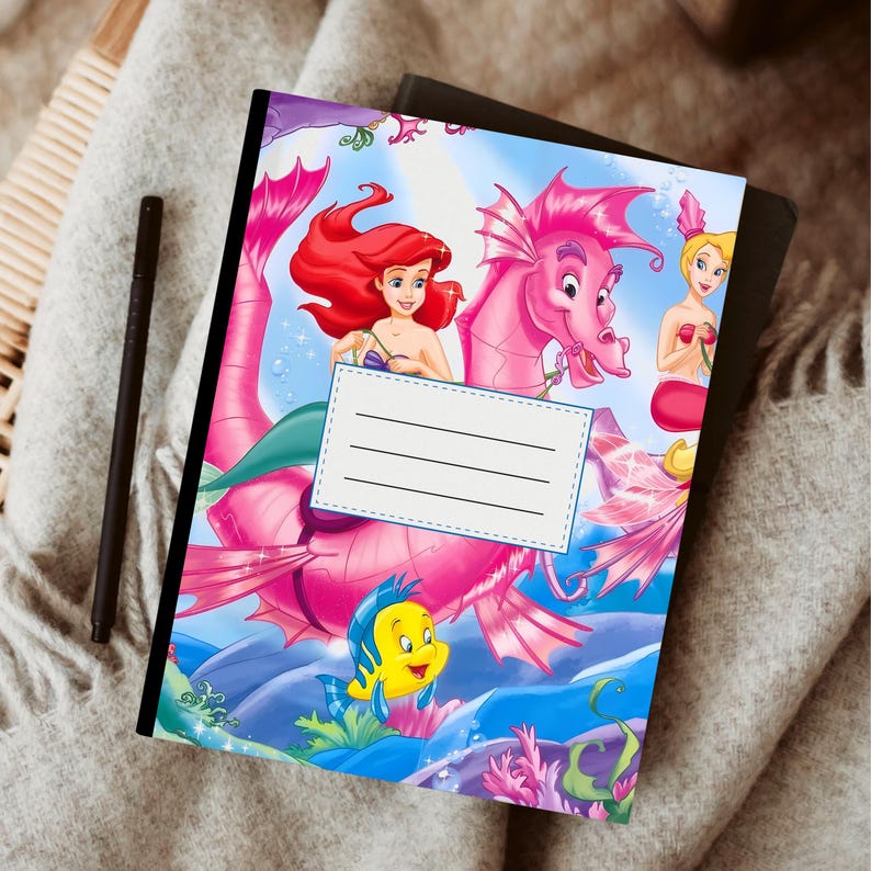 Puede incluir: Un cuaderno colorido con Ariel de La Sirenita. La portada presenta a Ariel, un caballito de mar rosa y otros personajes de la pel&iacute;cula. Incluye una etiqueta blanca con l&iacute;neas para escribir.