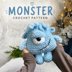 Puede incluir: Un monstruo de ganchillo azul claro con un ojo grande, brazos y piernas pequeños. El monstruo tiene una textura esponjosa y una boca sonriente. El texto "MONSTER CROCHET PATTERN" se muestra encima del monstruo.