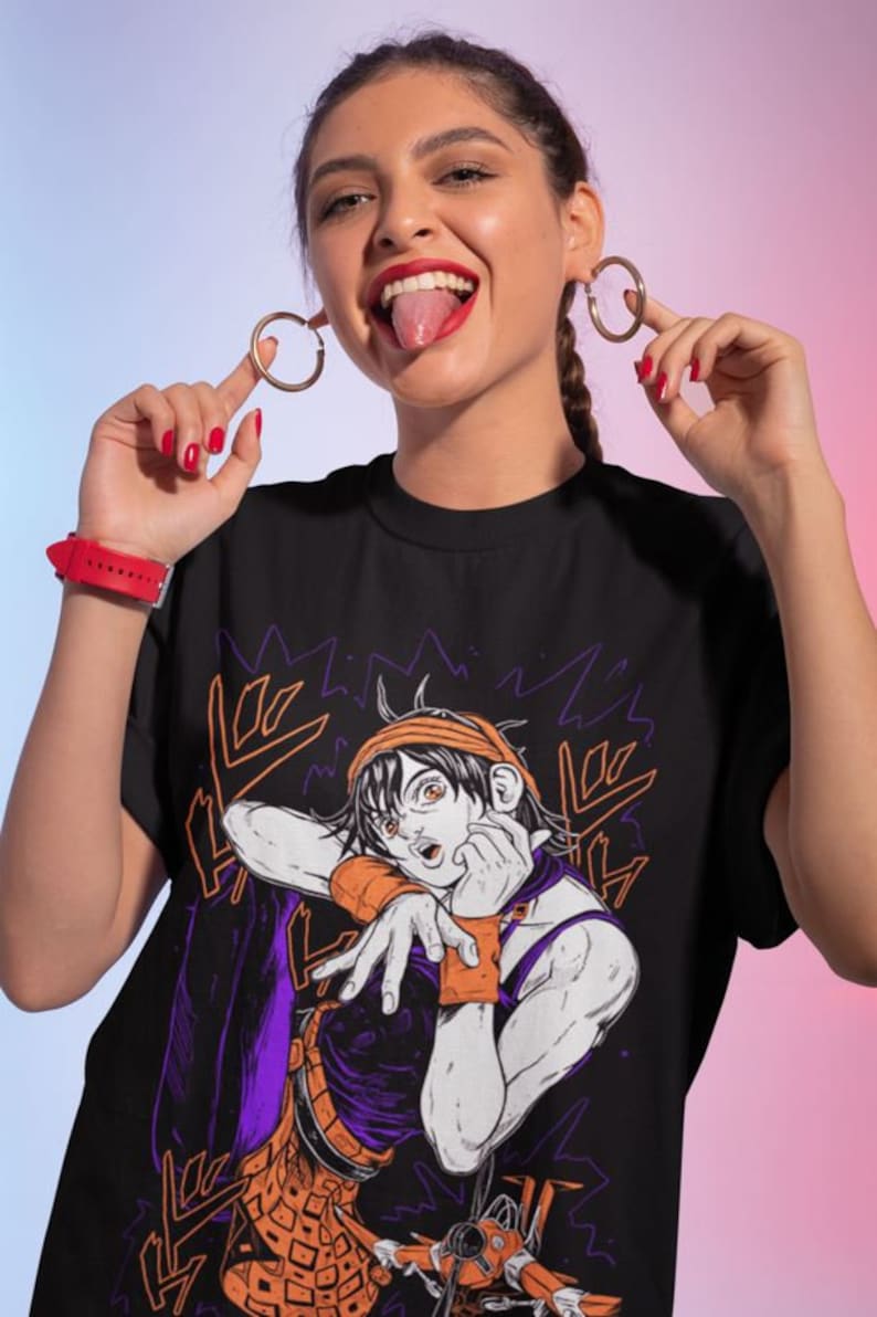 Może przedstawiać: Czarny T-shirt z nadrukiem graficznym postaci z kresk&oacute;wki w pomarańczowych i fioletowych ubraniach. Postać wykonuje gest ręką i ma zaskoczony wyraz twarzy. Tekst "ORA ORA" jest nadrukowany na koszulce japońskimi znakami.