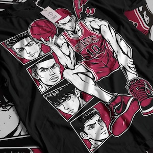 Può includere: Maglietta nera con una grafica di un giocatore di basket con una maglia rossa e bianca con la scritta "Shohoku" su di essa. Il giocatore sta saltando in aria e tiene una palla da basket. Ci sono immagini più piccole di altri giocatori di basket sullo sfondo.