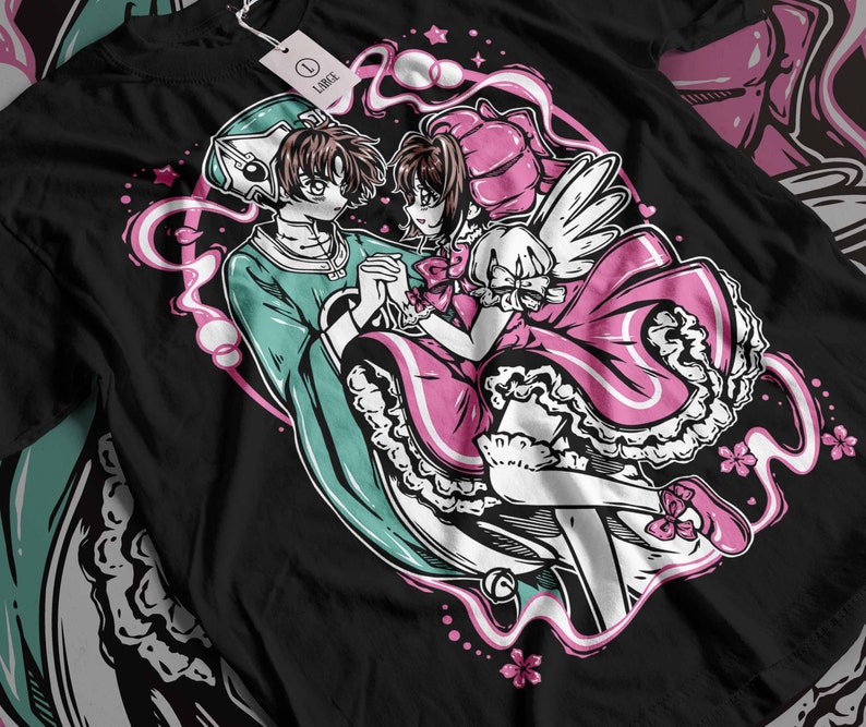 May include: A black t-shirt featuring a graphic print of two anime characters. The characters are a boy with green hair and a girl with pink hair. The boy is wearing a green outfit and the girl is wearing a pink dress. The background is a swirl of pink and white.