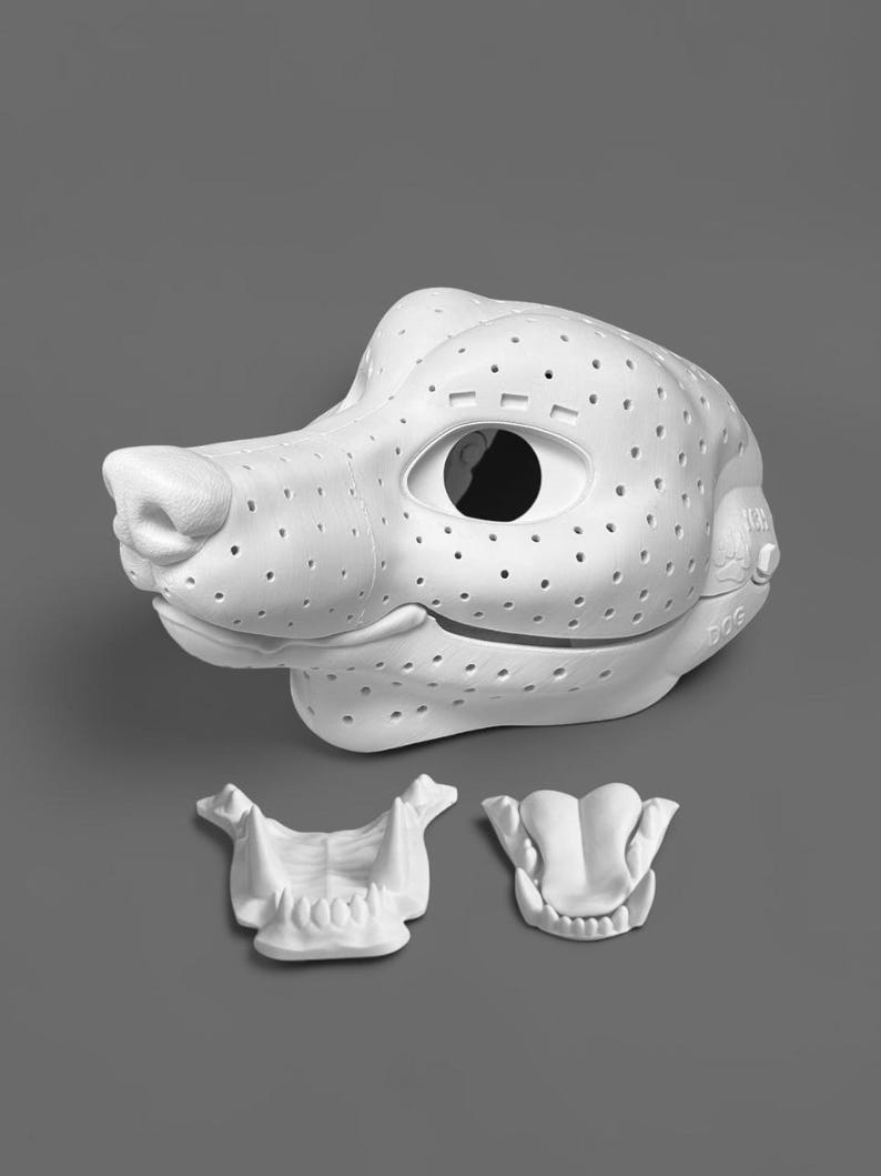 May include: A white 3D printed dog mask base featuring a perforated surface, large eye openings, and a snout. The set includes a separate white 3D printed jaw piece with teeth and a separate white 3D printed tongue piece with visible teeth details.