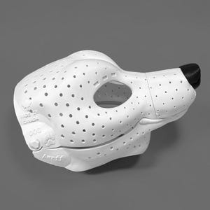 May include: A white, perforated dog-shaped mask with a black nose. The side features embossed text reading "MADE IN CANADA", "DOG", and "Awrff", along with a paw print icon. The mask has a hollow eye opening and a smooth, molded structure.