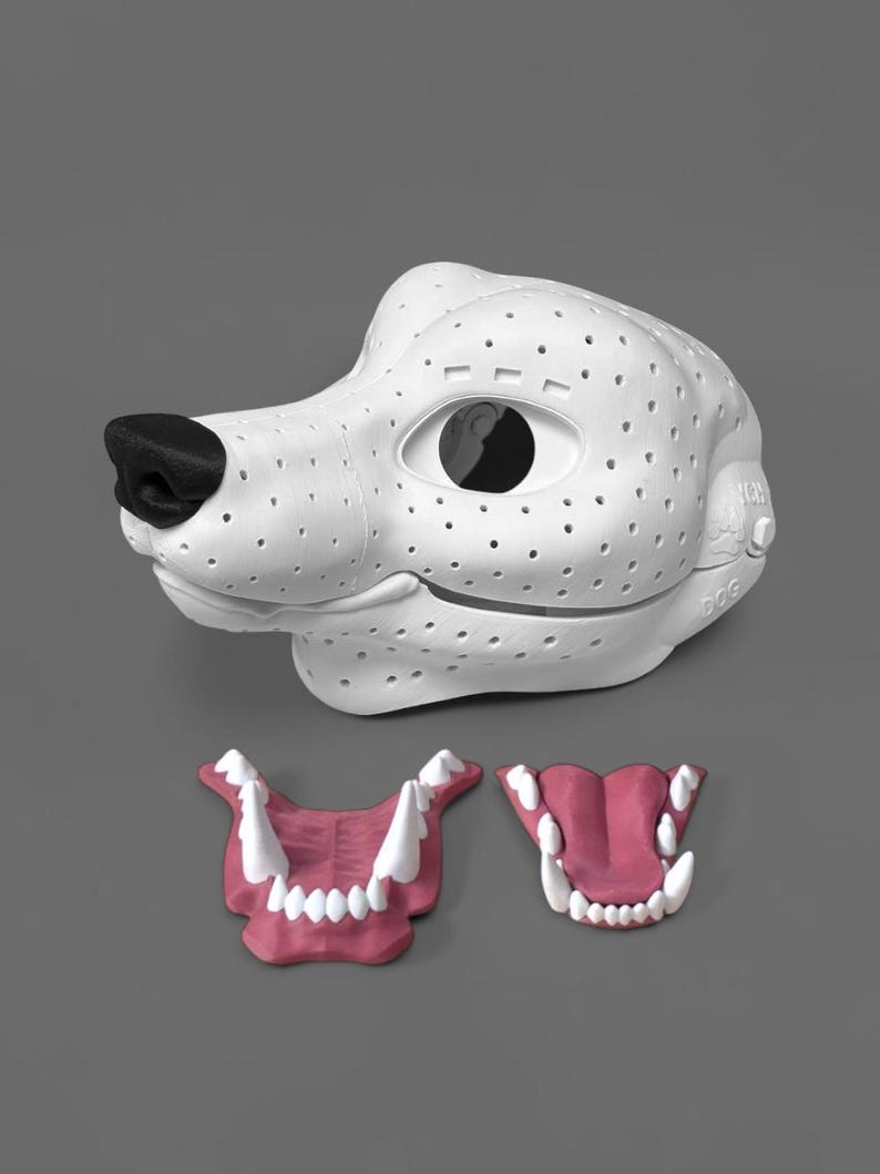 May include: A white 3D-printed dog mask base featuring a black nose and a perforated surface texture. The word DOG is embossed on the side. Two separate jaw inserts are included, each featuring pink gums and white teeth, one open and one closed.