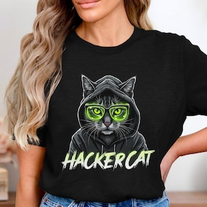 Könnte beinhalten: Schwarzes T-Shirt mit einem Aufdruck eines Katers, der einen schwarzen Kapuzenpullover und grün getönte Brillen trägt. Der Text "HACKER CAT" ist unter dem Kater aufgedruckt.