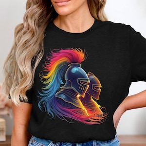 Könnte beinhalten: Schwarzes T-Shirt mit einer lebendigen Illustration von zwei Ritterhelmen. Die Helme sind mit einem Farbverlauf aus Blau, Gelb, Orange und Lila sowie einer regenbogenfarbenen Feder geschmückt. Das Design hat einen digitalen Kunststil.