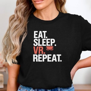 Może przedstawiać: Czarny T-shirt z białym napisem "Eat. Sleep. VR. Repeat." i czerwonym grafiką gogli VR.