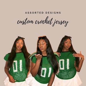 May include: Three women wearing green and white crochet jerseys with the number 01. The jerseys have a black trim and are paired with white skirts. The text "ASSORTED DESIGNS" and "custom crochet jersey" are displayed above the women.