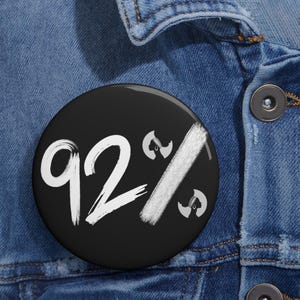 May include: A black button with white text that reads "92%" with a white diagonal line through it. There are two small black and white images of a woman's face with a head wrap on either side of the text.